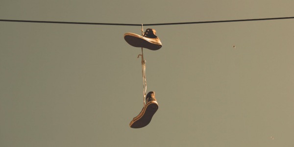 Scarpe appese ai fili: cosa si nasconde dietro il fenomeno delle scarpe volanti?